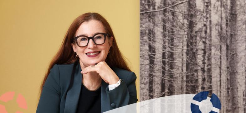 Pia Pakarinen on Helsingin seudun kauppakamarin toimitiusjohtaja. Taustalla keltainen seinä ja koivuverho.